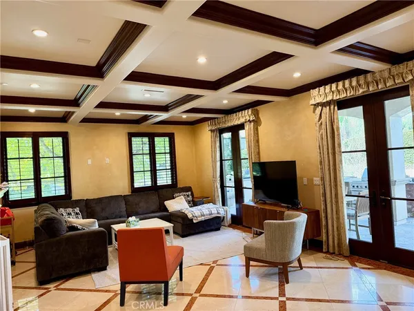 a living room with furniture a flat screen tv and large windows