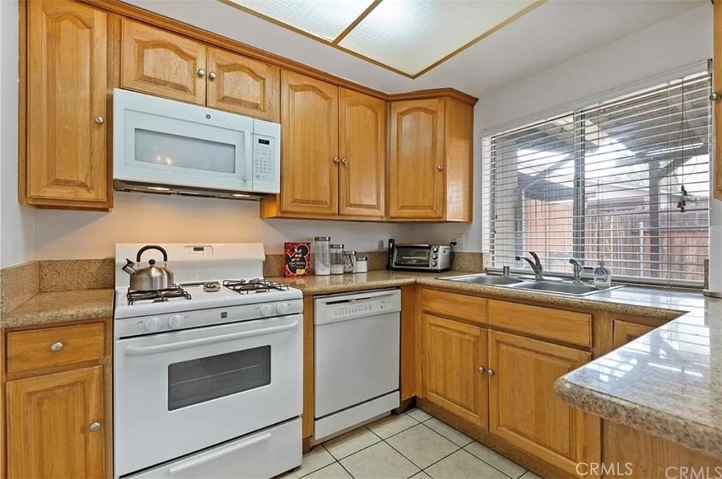 1375 Wheaton Way Riverside, CA 92507 - Photo 4 of 15 a kitchen with granite countertop cabinets stainless steel appliances a sink and a large window