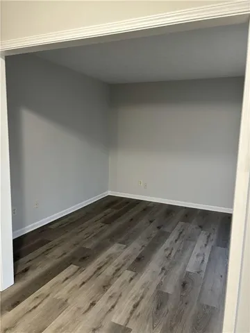 a view of a room that has wooden floor and white walls