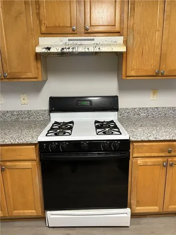 a stove top oven sitting inside of a kitchen