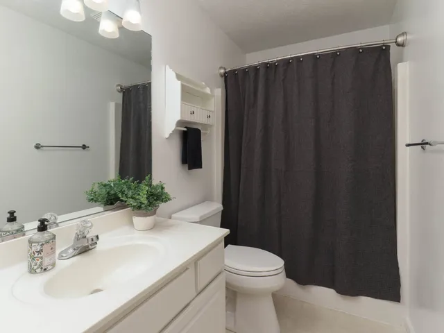 a bathroom with a sink and mirror with toilet