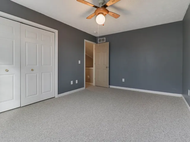 an empty room with a ceiling fan and a window