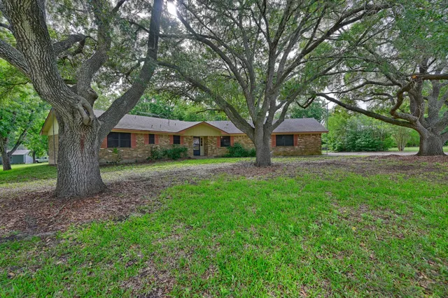 a front view of a house with a yard and tree