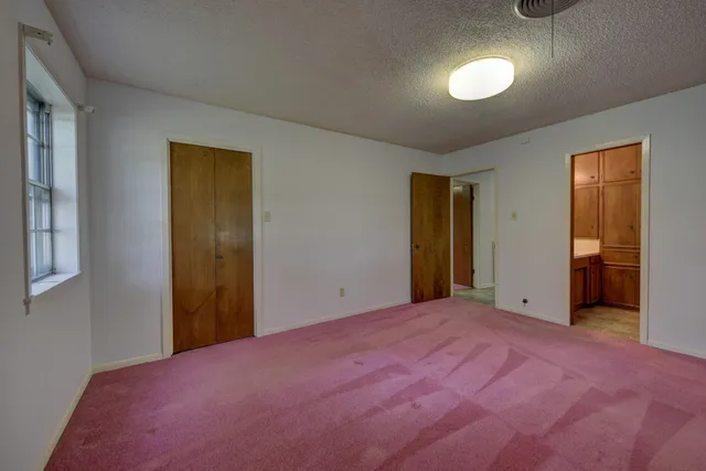 an empty room with windows and closet