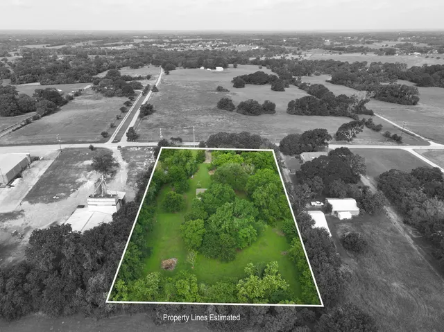 an aerial view of residential houses with outdoor space and trees