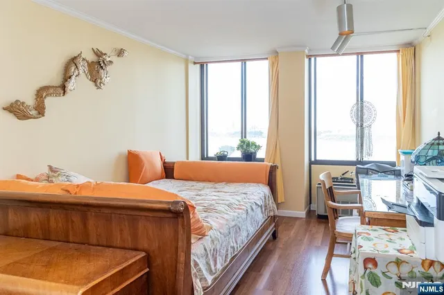 a bedroom with a bed and wooden floor