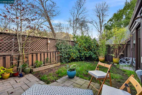 a backyard of a house with barbeque oven table and chairs