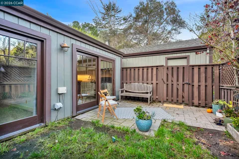a backyard of a house with wooden floor fence and outdoor seating