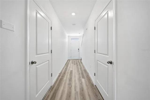 a view of a hallway with wooden floor and staircase