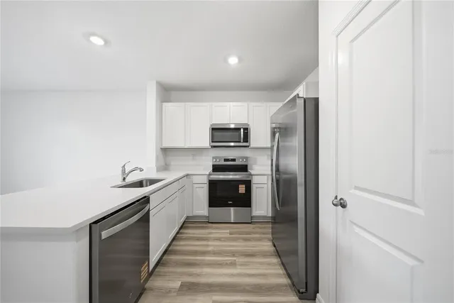 a kitchen with stainless steel appliances granite countertop a refrigerator and a stove