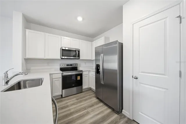 a kitchen with a refrigerator sink and microwave