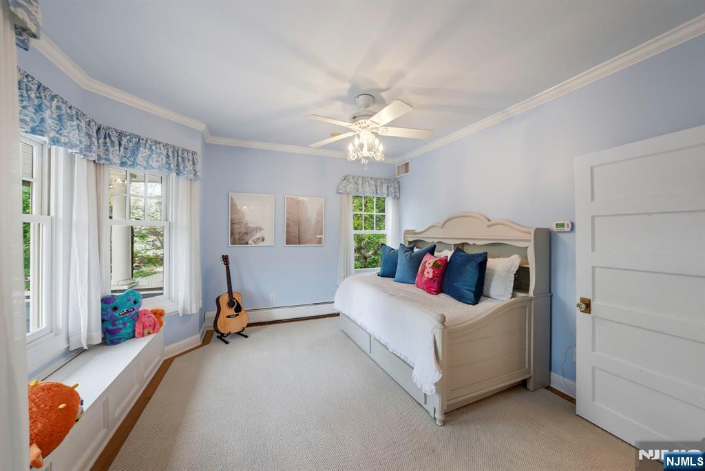 203 Heights Road Ridgewood, NJ 07450 - Photo 18 of 41 a bed room with a bed and a chandelier