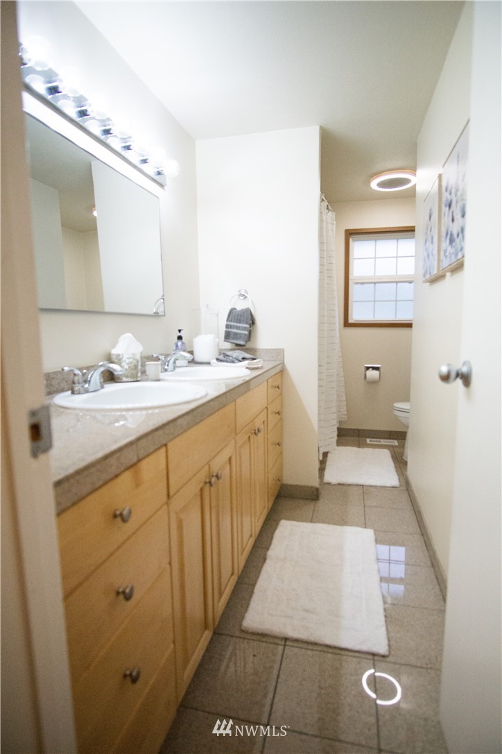 306 216th Street Southwest Bothell, WA 98021 - Photo 18 of 31 a bathroom with a double vanity sink and mirror