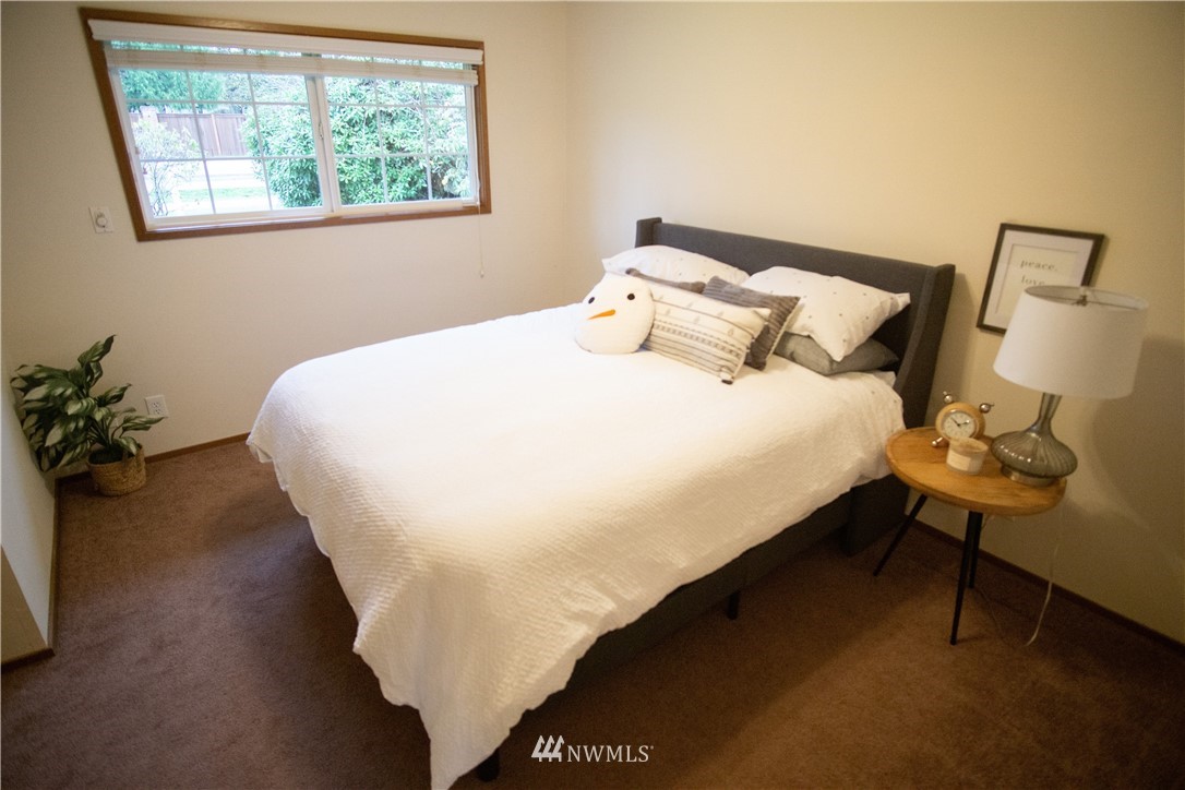 306 216th Street Southwest Bothell, WA 98021 - Photo 21 of 31 a large bed sitting in a bedroom next to a window