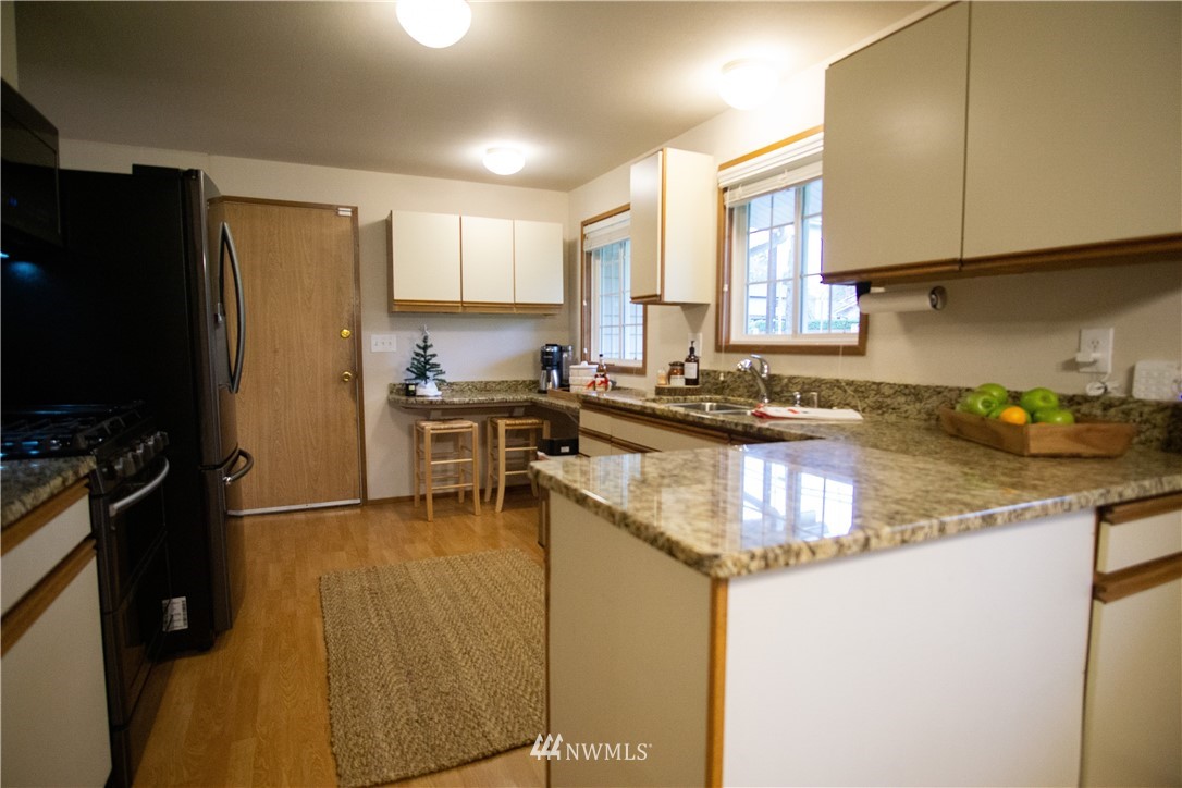 306 216th Street Southwest Bothell, WA 98021 - Photo 5 of 31 a kitchen with granite countertop a sink stove and refrigerator