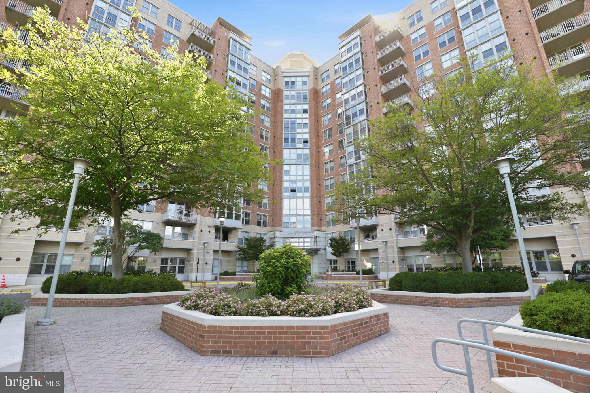 11800 Sunset Hills Road, Unit 218 Reston, VA 20190 - Photo 36 of 38 a white building with outdoor seating and yard