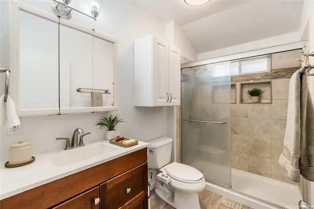 a bathroom with a sink a toilet and shower