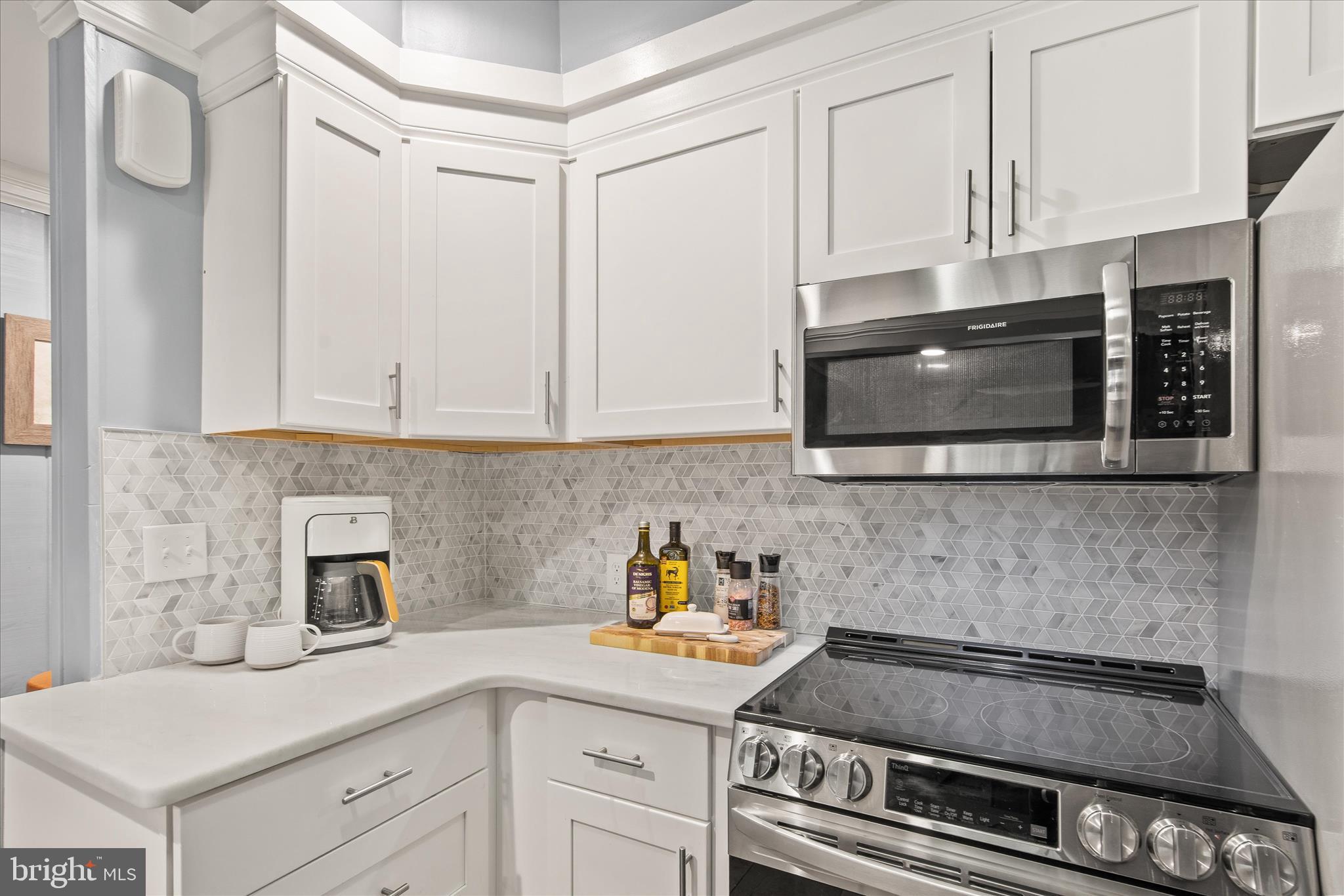 12107 Angler Road Ocean City, MD 21842 - Photo 20 of 106 a kitchen with stainless steel appliances granite countertop white cabinets and a stove a oven with white countertops