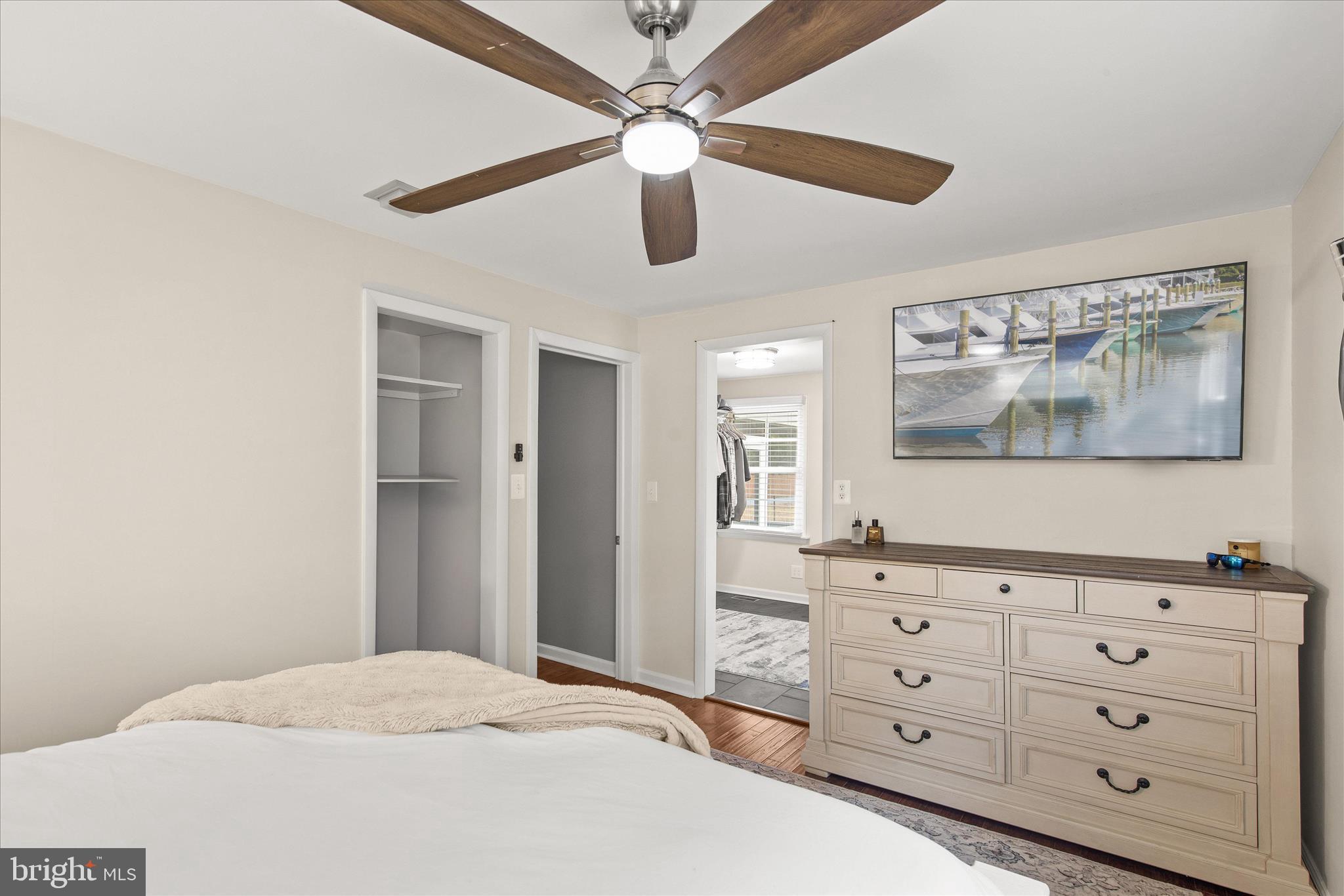 12107 Angler Road Ocean City, MD 21842 - Photo 37 of 106 a bedroom with a bed a dresser and a painting