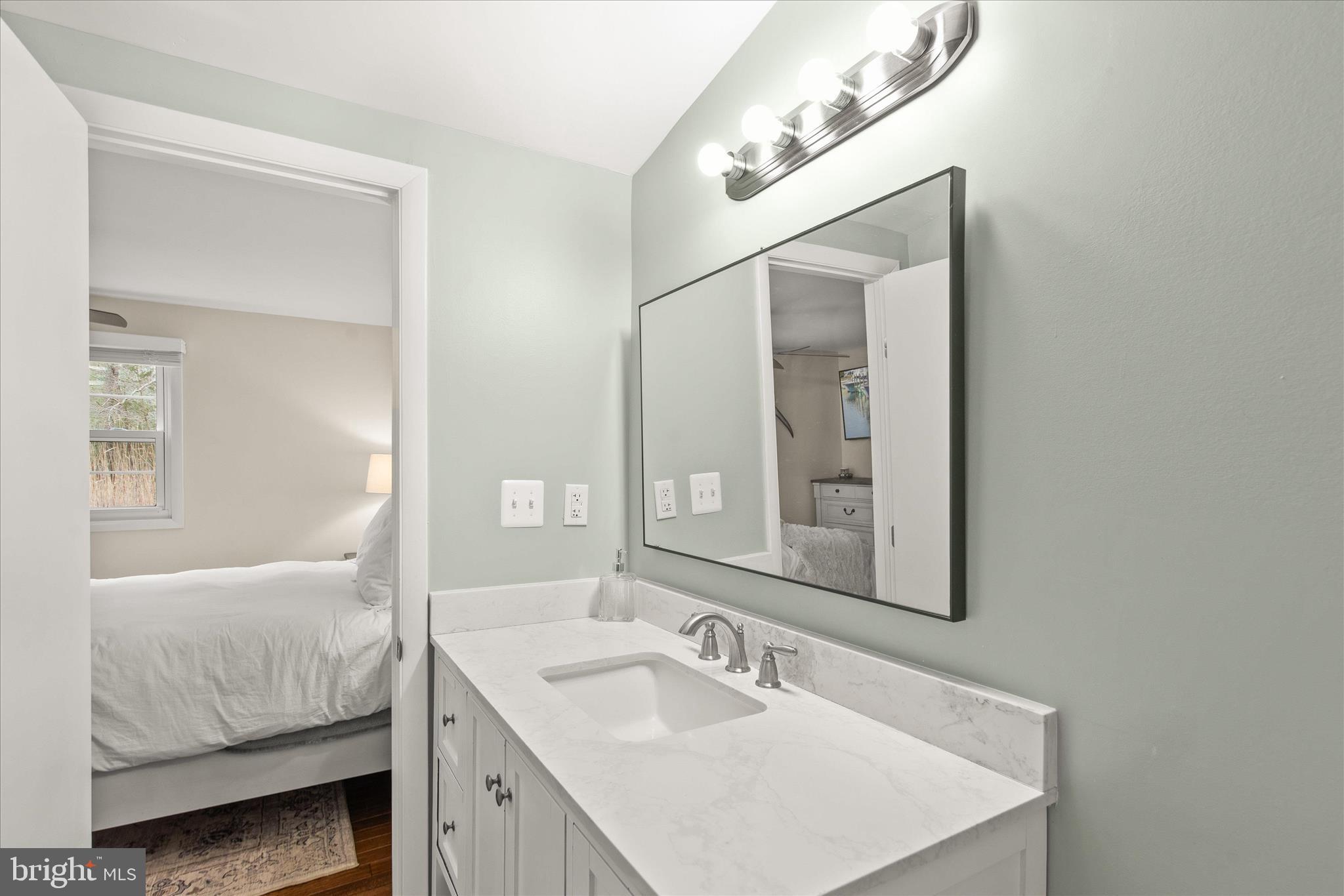 12107 Angler Road Ocean City, MD 21842 - Photo 40 of 106 a en suite bathroom with a double vanity sink and a mirror