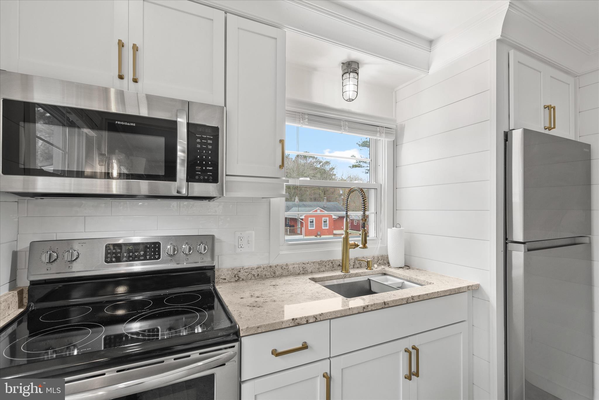 12107 Angler Road Ocean City, MD 21842 - Photo 65 of 106 a kitchen with stainless steel appliances granite countertop a stove and a microwave