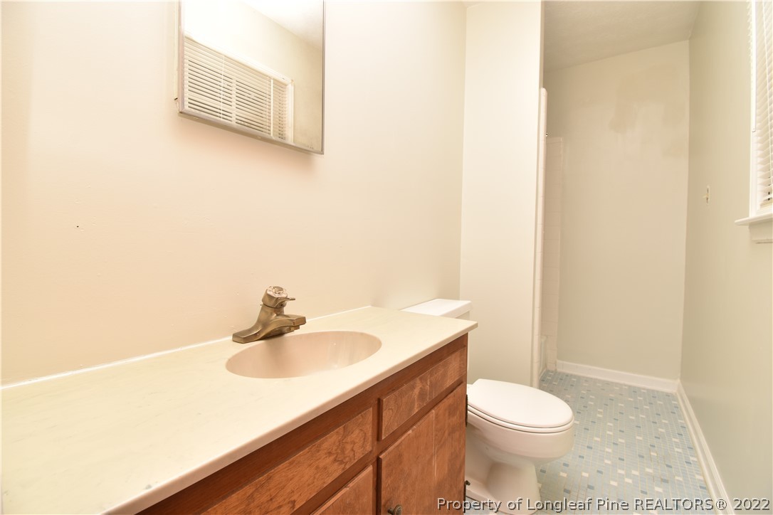 5401 Chesapeake Road Fayetteville, NC 28311 - Photo 9 of 17 a bathroom with a sink a toilet and mirror