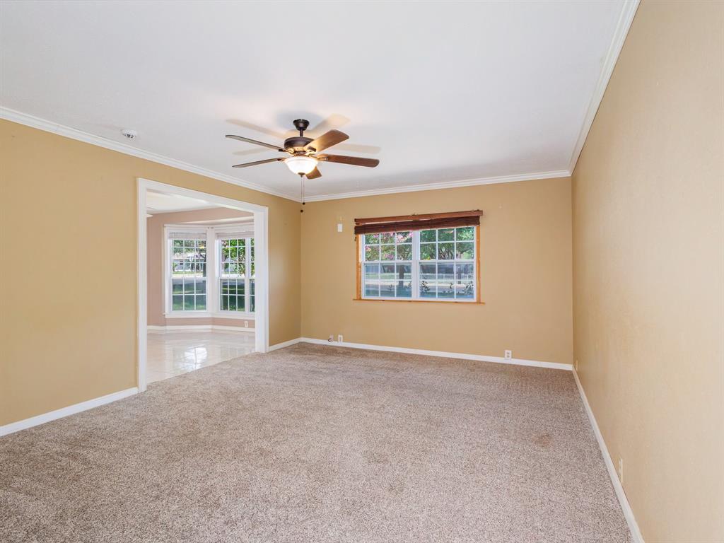 4002 Austin Avenue Brownwood, TX 76801 - Photo 12 of 34 an empty room with windows and chandelier fan