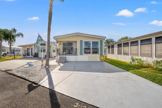 a view of a house with a yard and potted plants