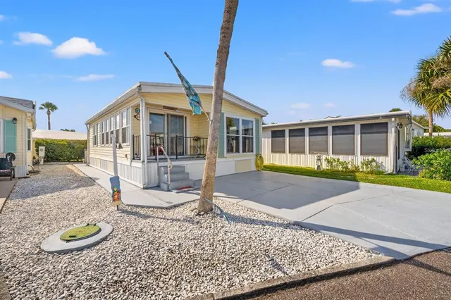 a front view of a house with a yard and potted plants