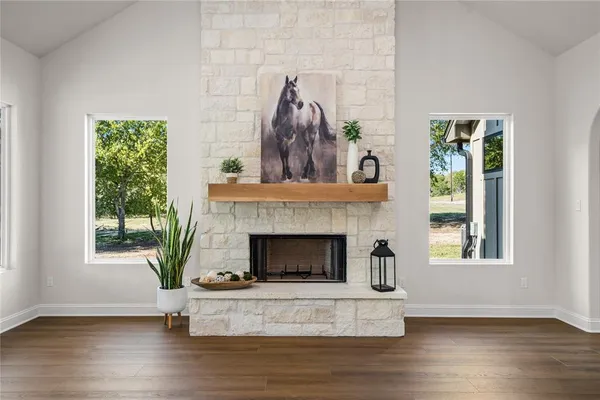 an empty room with windows fireplace and mountain view