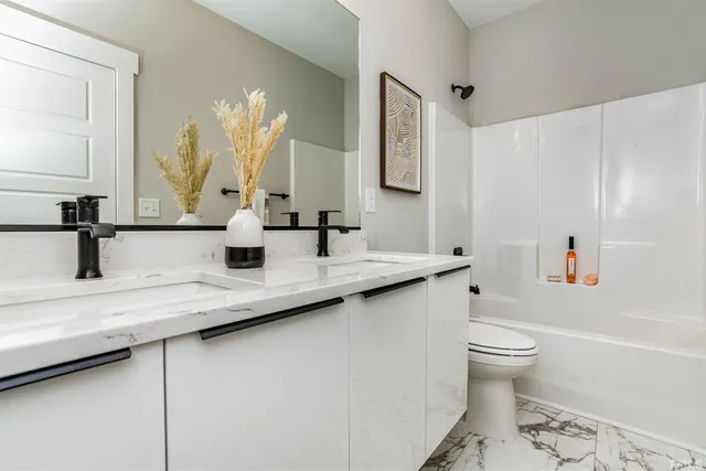 a bathroom with a granite countertop sink a toilet and a mirror