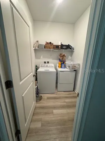 a utility room with a wooden floor washer and dryer