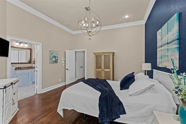 a spacious bedroom with a bed and a chandelier