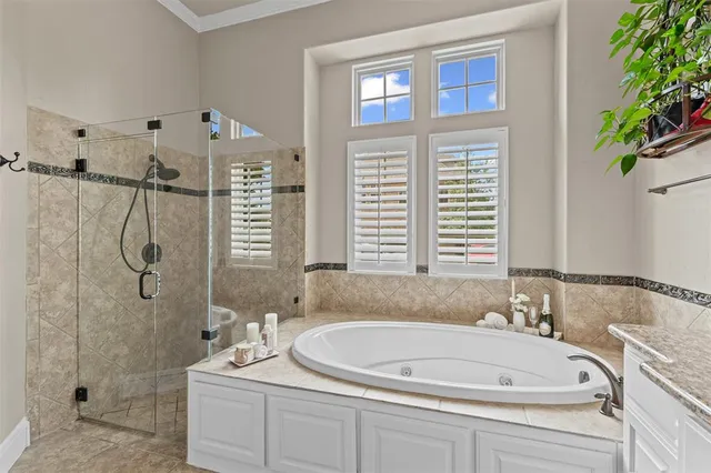 a bathroom with a tub a sink a window and a shower