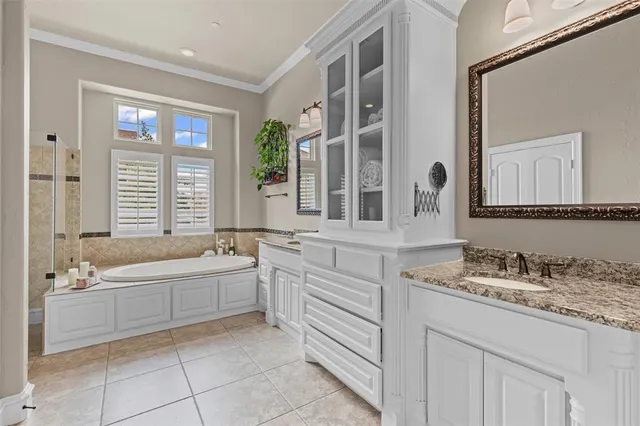 a bathroom with a granite countertop sink and a bathtub