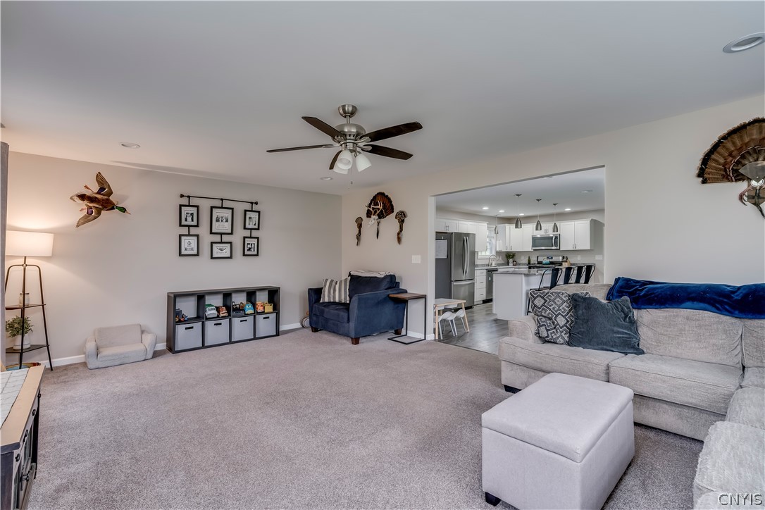 22168 Swan Road Watertown Town, NY 13601 - Photo 49 of 49 An open floor plan seamlessly connects this carpeted living space to the kitchen beyond.