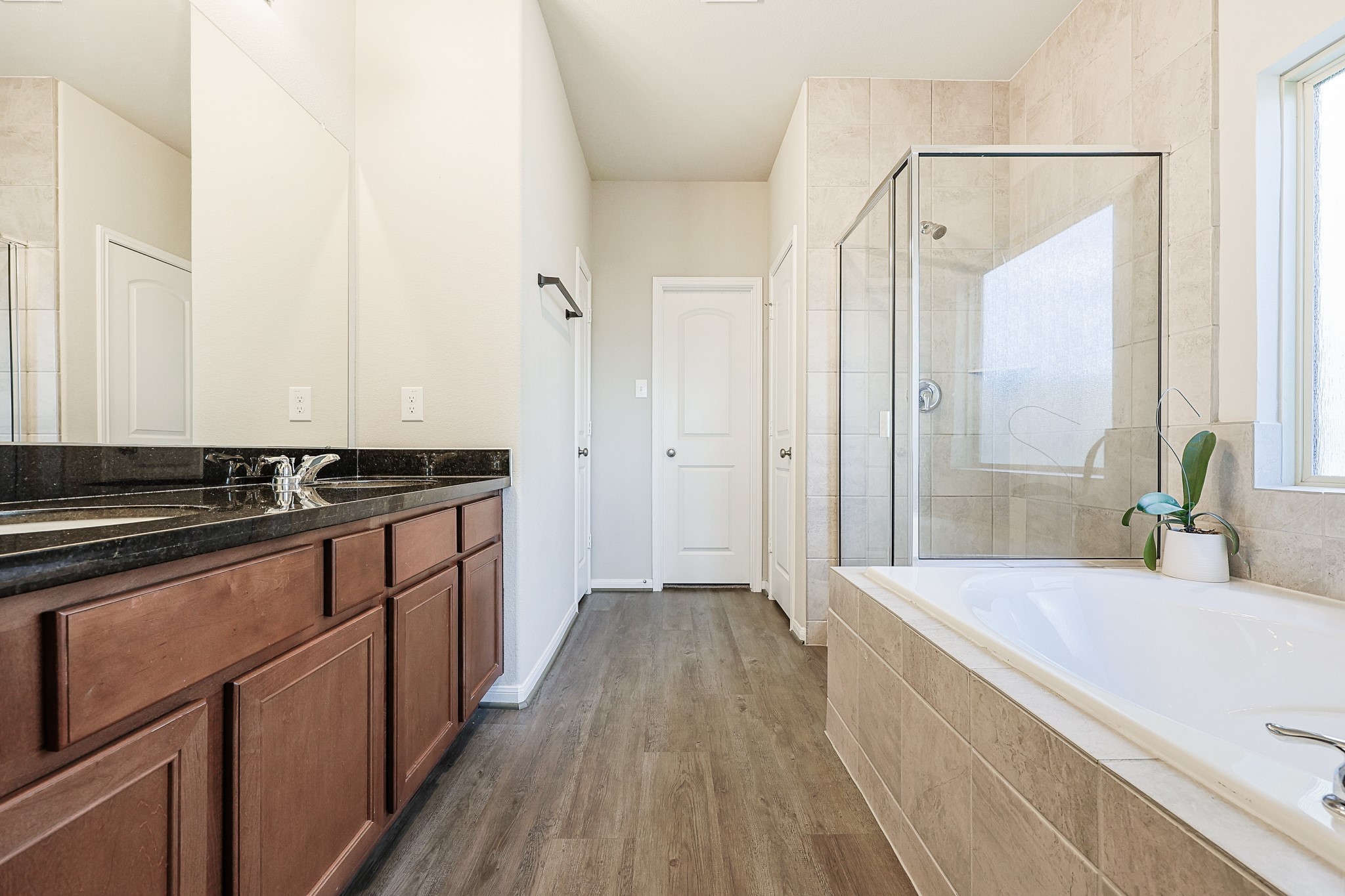 10423 Rochester Hls Lane Tomball, TX 77375 - Photo 19 of 36 Designed for both luxury and everyday convenience, the space features an expansive double vanity with elegant wood cabinetry, providing abundant storage and plenty of counter space.