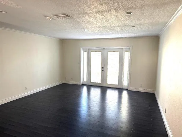 a view of a backyard with plants and white house