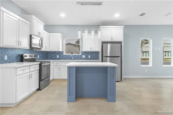 a kitchen with stainless steel appliances granite countertop a stove a sink and a refrigerator