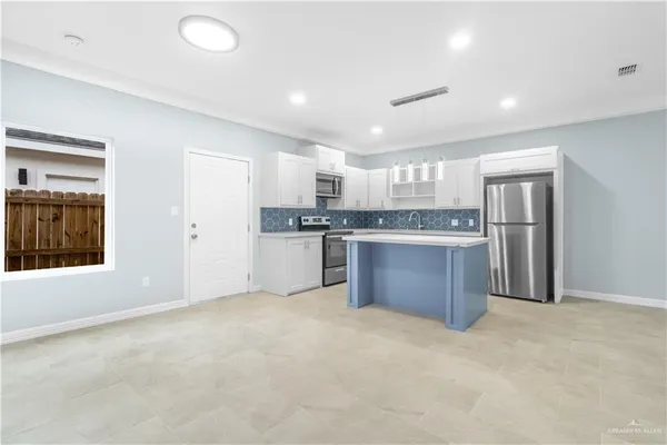 a kitchen with stainless steel appliances granite countertop a stove top oven a sink and a refrigerator