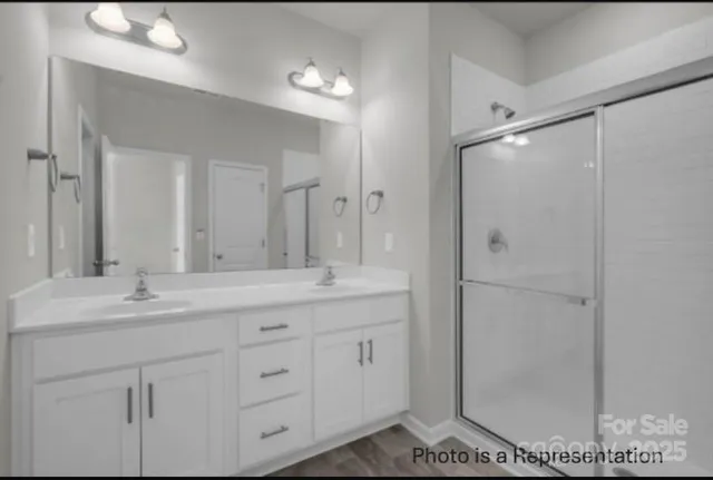 a bathroom with a double vanity sink mirror and shower
