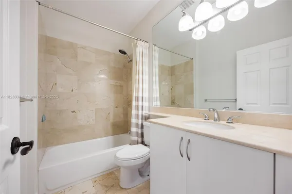a bathroom with a sink vanity mirror and toilet