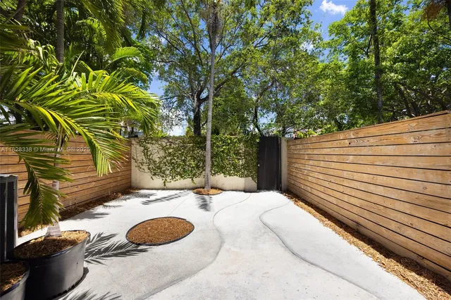 a view of a patio with table and chairs with wooden floor and fence