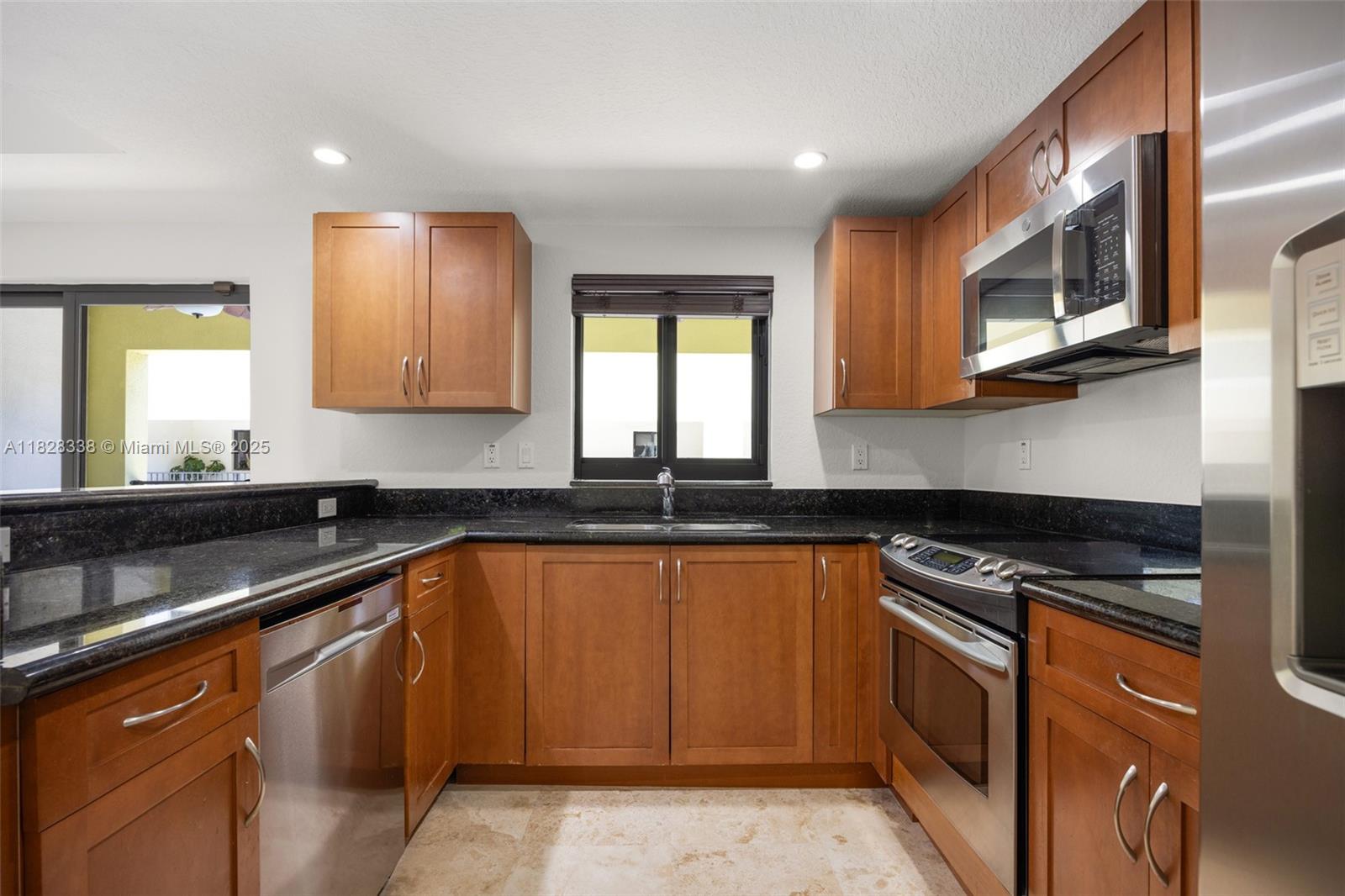 3204 Bird Avenue, Unit 108 Coconut Grove, FL 33133 - Photo 10 of 19 a kitchen with stainless steel appliances granite countertop a sink stove and microwave