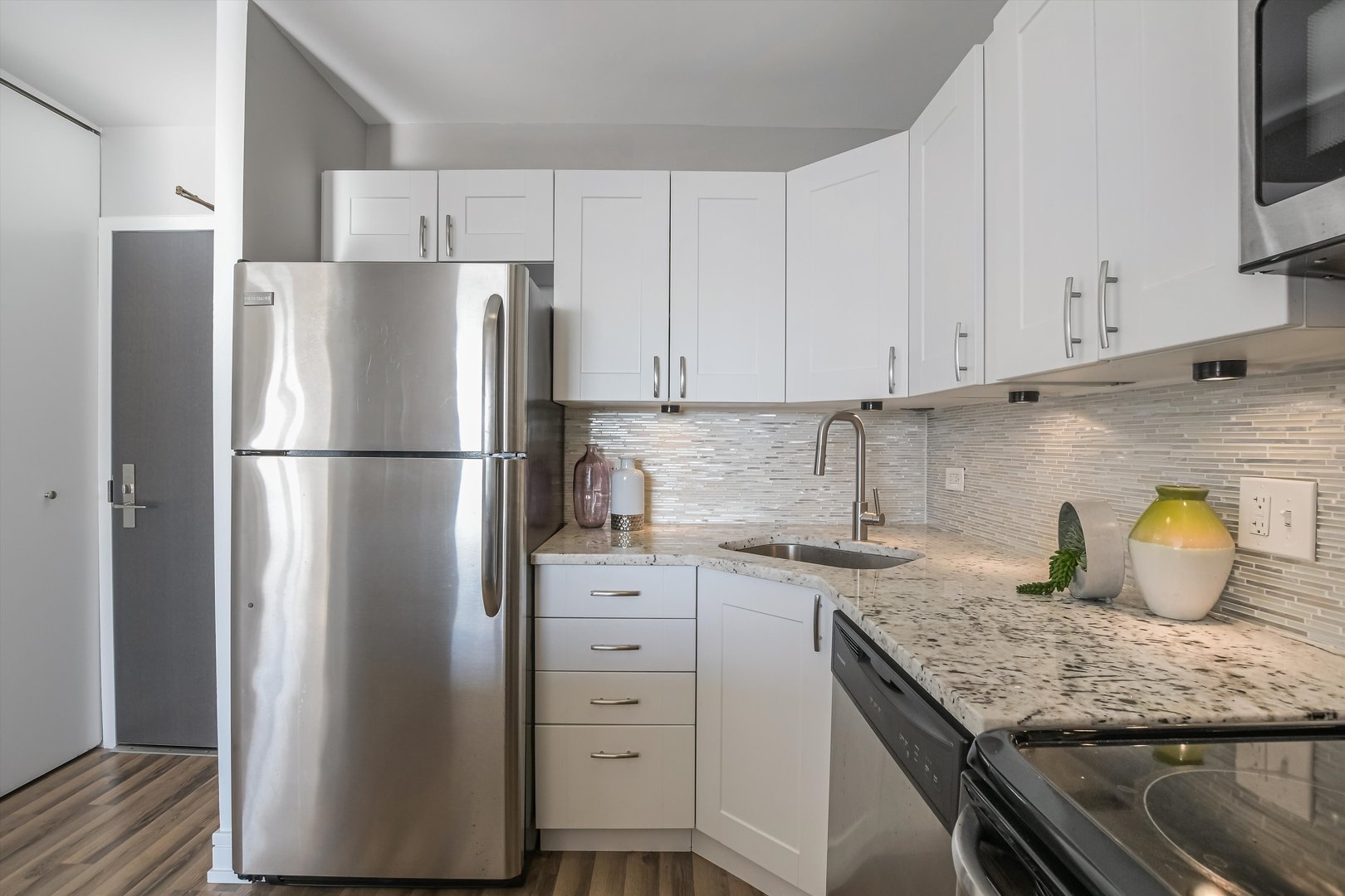 3930 North Pine Grove Avenue, Unit 2308 Chicago, IL 60613 - Photo 9 of 29 a kitchen with granite countertop a refrigerator sink and cabinets