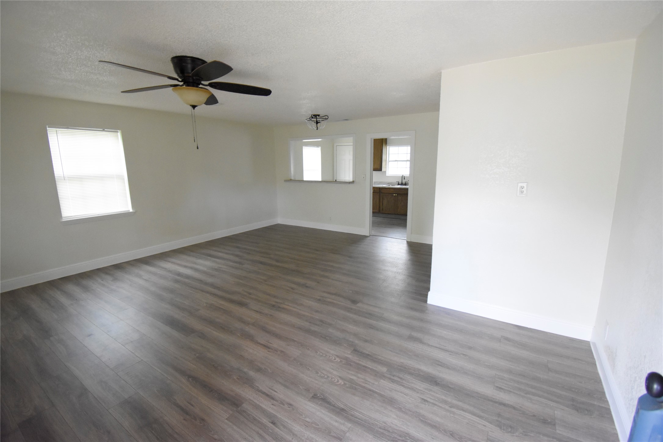 6229 Clover Ridge Street Houston, TX 77087 - Photo 10 of 25 an empty room with wooden floor chandelier and windows