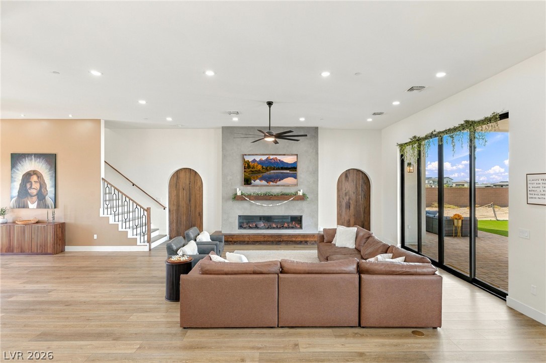 324 Wanda Road Henderson, NV 89002 - Photo 10 of 96 Recessed lighting and wide-plank flooring define this airy living space featuring a modern fireplace.