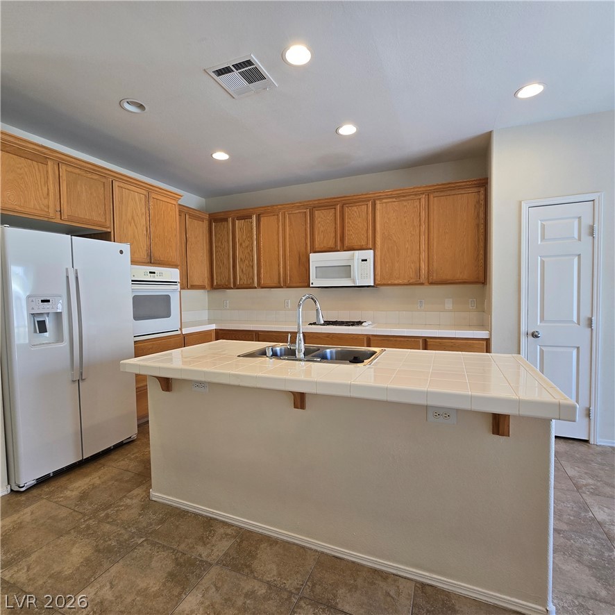 9234 Kingston Road Henderson, NV 89074 - Photo 17 of 38 A well-lit kitchen with a central island and a full suite of essential appliances.