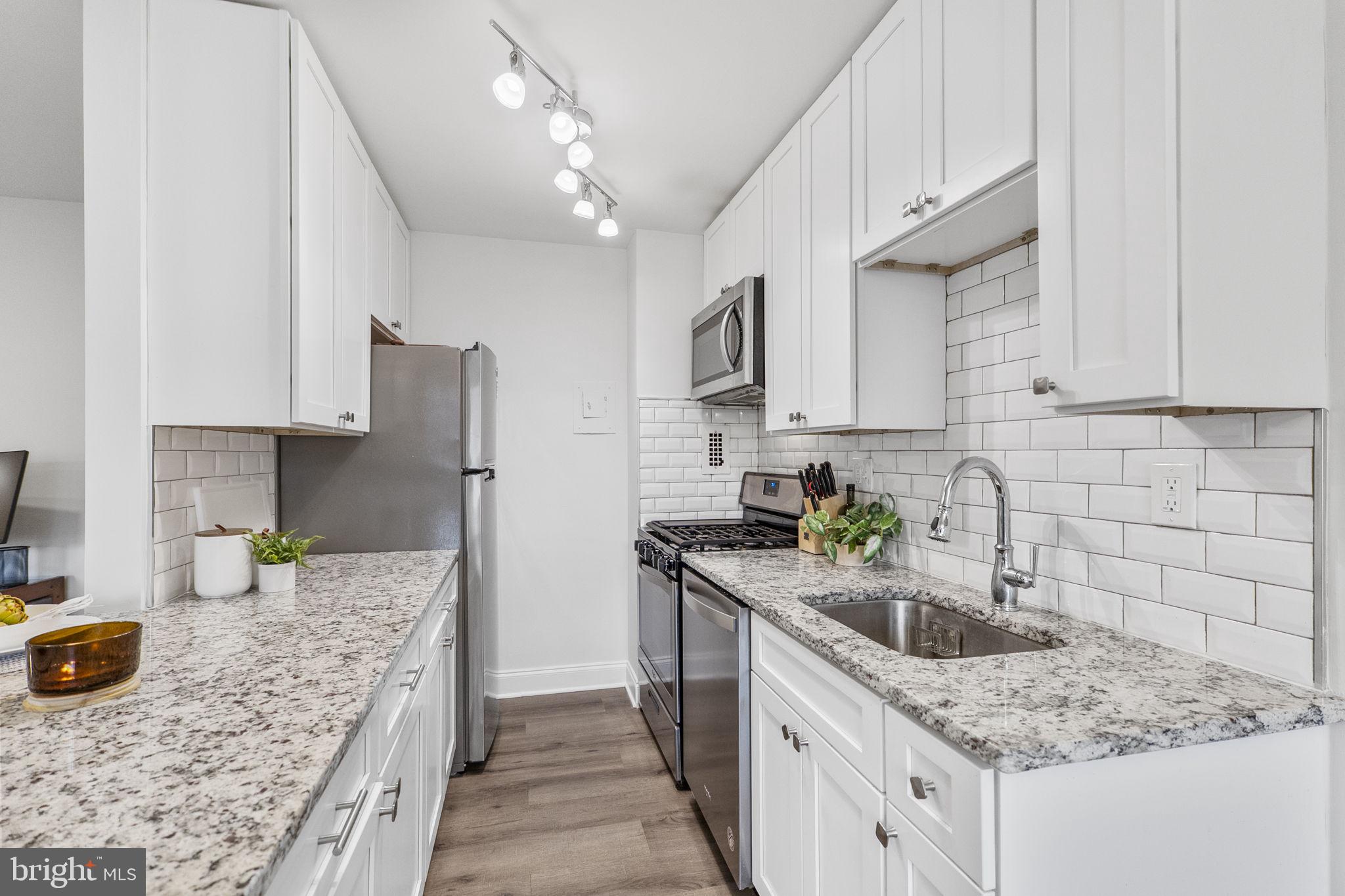 8601 Manchester Road, Unit 220 Silver Spring, MD 20901 - Photo 13 of 27 a kitchen with stainless steel appliances granite countertop a sink stove and refrigerator