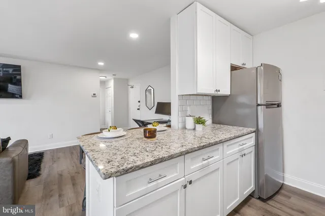 a kitchen with stainless steel appliances granite countertop a sink refrigerator and cabinets